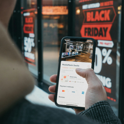 Une personne tenant son smartphone affichant des infos sur le Black Friday